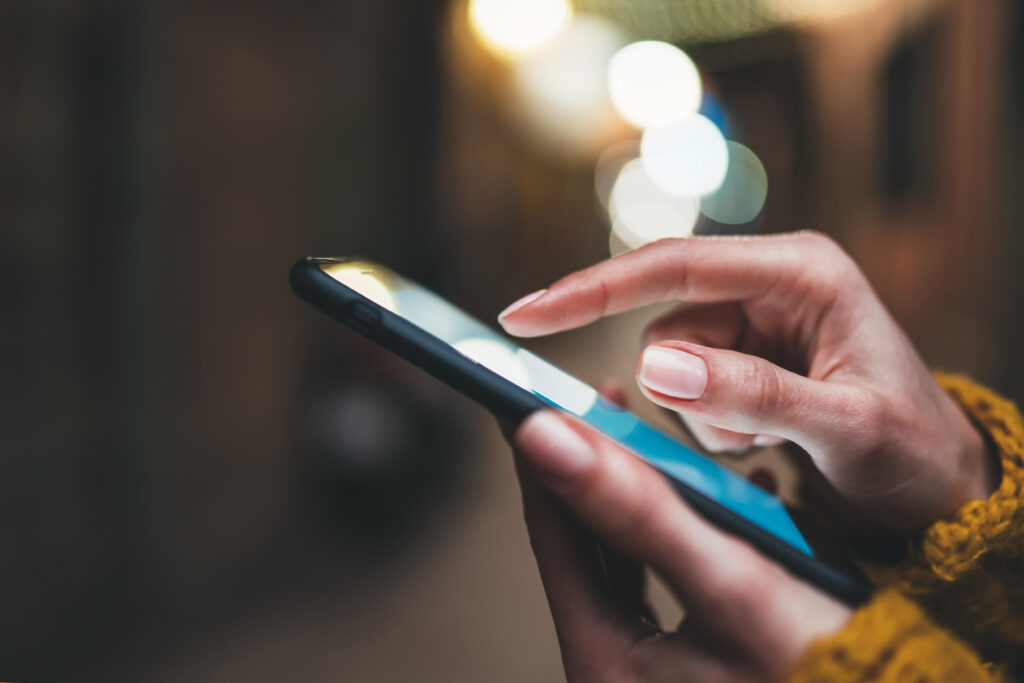 Woman typing number into cellphone